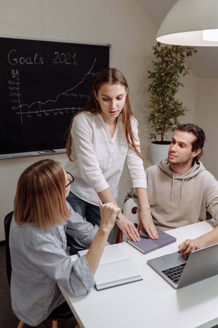 Coworkers discussing and planning 2021 goals in a modern office setting.